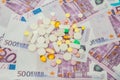 Money and pills. Pills of different colors on money. medicine concept. Euro cash. The rise in the cost of medical care Royalty Free Stock Photo