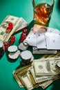 Money, playing cards, dice and casino tokens near glass of cognac on green Royalty Free Stock Photo