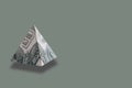 Money pyramid on green background. Copy space.