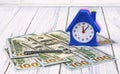 Money for real estate, home loan concept. Dollar banknotes, an alarm clock in the form of a house and a key to an apartment Royalty Free Stock Photo