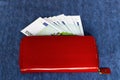 Money in a red purse on a blue background Royalty Free Stock Photo