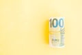 Money roll of euro banknotes yellow rubber band on yellow background Royalty Free Stock Photo