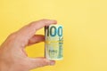 Money roll of euro banknotes yellow rubber band on yellow background Royalty Free Stock Photo