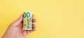 Money roll of euro banknotes yellow rubber band on yellow background Royalty Free Stock Photo