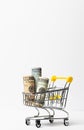 Money rolled up in a tube in a cart on a white background. Copy space. Close-up. Sales and shopping concept. Vertical