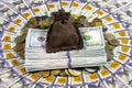 A money sack and a stack of American dollar bills on a pile of different coins from around the world against the background of one Royalty Free Stock Photo