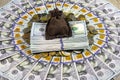 A money sack and a stack of American dollar bills on a pile of different coins from around the world against the background of one Royalty Free Stock Photo