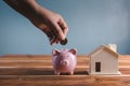 Money Savings for Future Property House Concept, Hand is Putting Coin Into Piggy Bank for Saving Future Housing Real Estate Royalty Free Stock Photo