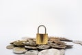 Money and Security Concept. Close up of gold master key lock on pile of coins on white background with copy space for text Royalty Free Stock Photo