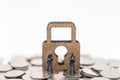 Money and Security Concept. Two soldier /police guard miniature figures people standing on pile of coins with wooden master key