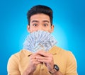 Money, shocked face and man with financial surprise, winning or savings mistake  on blue, studio background Royalty Free Stock Photo