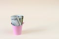 Money in a small, pink bucket. Copy space - concept of economy, crisis, business, savings, support Royalty Free Stock Photo