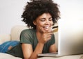 Money spent well. a woman using her laptop on the sofa at home while holding a bankcard.