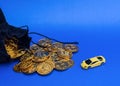 Money spilling out of black bag and a toy car on blue background Royalty Free Stock Photo