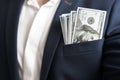 Money success concept. 100 dollar bills in businessman jacket pocket. Symbol of success and wealth