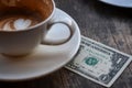 Money tip service, Coffee cup on wooden table. Royalty Free Stock Photo