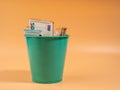 Money in the trash can on an orange background. Euros in the trash. Waste of money concept. Royalty Free Stock Photo