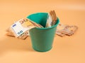 Money in the trash can on an orange background. Euros in the trash. Waste of money concept. Royalty Free Stock Photo