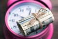 Money US dollars in a roll tied with a rope  on the clock, time is money, it`s time to make money Royalty Free Stock Photo