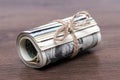 Money US dollars in a roll tied with a rope on a dark wooden background Royalty Free Stock Photo