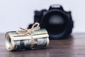 Money US dollars in a roll tied with a rope near the camera. Salary for the work of a photographer Royalty Free Stock Photo