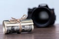 Money US dollars in a roll tied with a rope near the camera. Salary for the work of a photographer Royalty Free Stock Photo