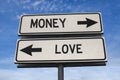 Money vs love. White two street signs with arrow on metal pole with word