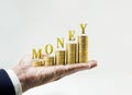 Money word with money coin stacked growing on Businessman hand. Royalty Free Stock Photo