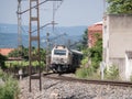 Locomotive of the Renfe company pulling freight wagons leaves a curve in the track