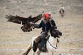 Mongolia. Traditional Golden Eagle Festival. Unknown Mongolian Hunter Berkutchi On Horse With Golden Eagle. Falconry In West M Royalty Free Stock Photo