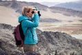 Mongolia Ulgii 2019-05-04 European beautiful girl in blue jacket looking through binocular into the distance, eagle