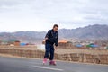 Mongolia Ulgii 2019-05-05 Mongolian boy in colorful clothes rides pink inline skates on road in asian village on