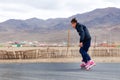 Mongolia Ulgii 2019-05-05 Mongolian boy in colorful clothes rides pink inline skates on road in asian village on