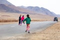 Mongolia Ulgii 2019-05-05 Mongolian girl in colorful clothes run on the road after leaving car. Concept orphan, foster