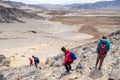 Mongolia Ulgii 2019-05-04 Tourist group go hiking, climbing together with guide, coming down from mountain top. Back view. Concept