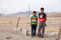 Mongolia Ulgii 2019-05-05 Two Mongolian boys in colorful clothes stand near fence of barbed wire in steppe on background