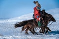 Mongolian cowboy in traditional costumes riding wild horses on the ice
