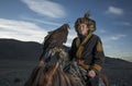 Mongolian eagle hunter with his eagle and horse