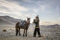 Mongolian eagle hunter with his eagle and horse