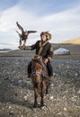 Mongolian eagle hunter with his eagle and horse