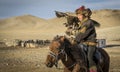 Mongolian eagle hunter with his eagle and horse