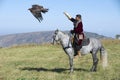 Mongolian hunter launches golden eagle to pursue prey circa Almaty, Kazakhstan. Royalty Free Stock Photo