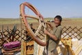 Mongolian man assembles yurt in steppe, circa Harhorin, Mongolia.