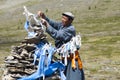 Mongolian man ties ribbon to sacred shrine