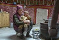 Mongolian nomad woman with her kid inside her home yurt
