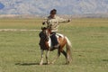 Mongolian woman rides on horseback circa Harhorin, Mongolia.