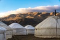 Mongolian yurts in front of mountains and blue sky