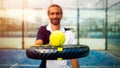 Monitor of padel holding black racket with yellow tennis ball over. Paddel class Royalty Free Stock Photo