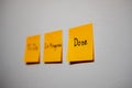 Monitor task of work concept, To do, In progress, Done Note reminder yellow sticker or post note on a white wall close up,. Royalty Free Stock Photo