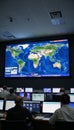 Monitoring global events or disasters through CCTV in a control room using satellite technology for worldwide coverage on screens